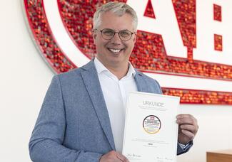 Christian Rothe, Mitglied der Geschäftsführung der Abus Gruppe, mit der offiziellen Urkunde des „Life & Living Award 2022“. 